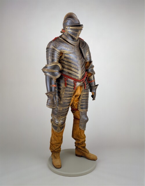The armor is an early example of the “anime” type, in which the breastplate and backplate are constructed of horizontal overlapping plates connected and made flexible by rivets and internal leather straps. The decoration, consisting of foliage, putti, running dogs, and Renaissance candelabra and grotesque ornament, is typically Italian.